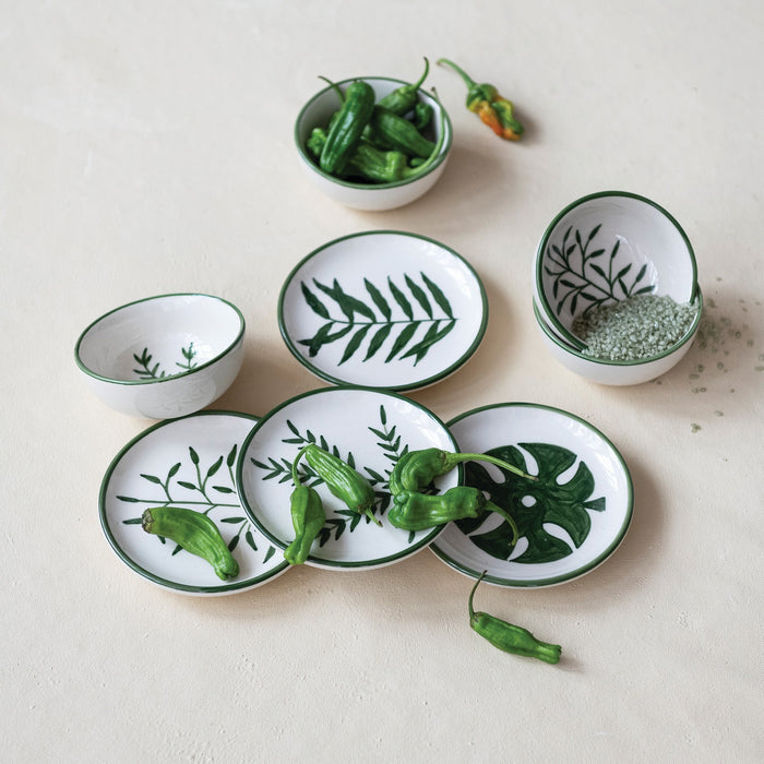Set of four CREATIVE COOP HAND-PAINTED STONEWARE PLATES, each with a unique botanical design and green rim. Delicate green leaf patterns make every appetizer plate an artful addition to your table.