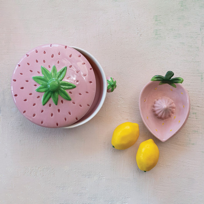 Two views of the HAND-PAINTED STONEWARE STRAWBERRY SHAPED JUICER by CREATIVE COOP: a unique artisan piece with pink strawberry design and green leaves, shown from both the top and side—perfect kitchen decor for fruit lovers.