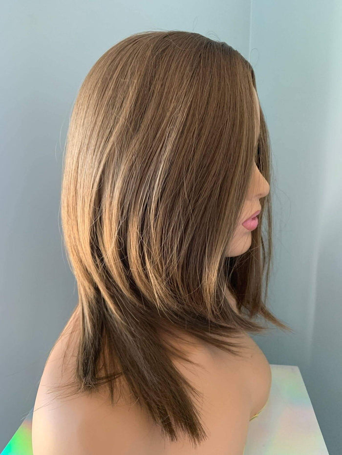 Mannequin head with brown hair styled in a bob cut against a light gray background