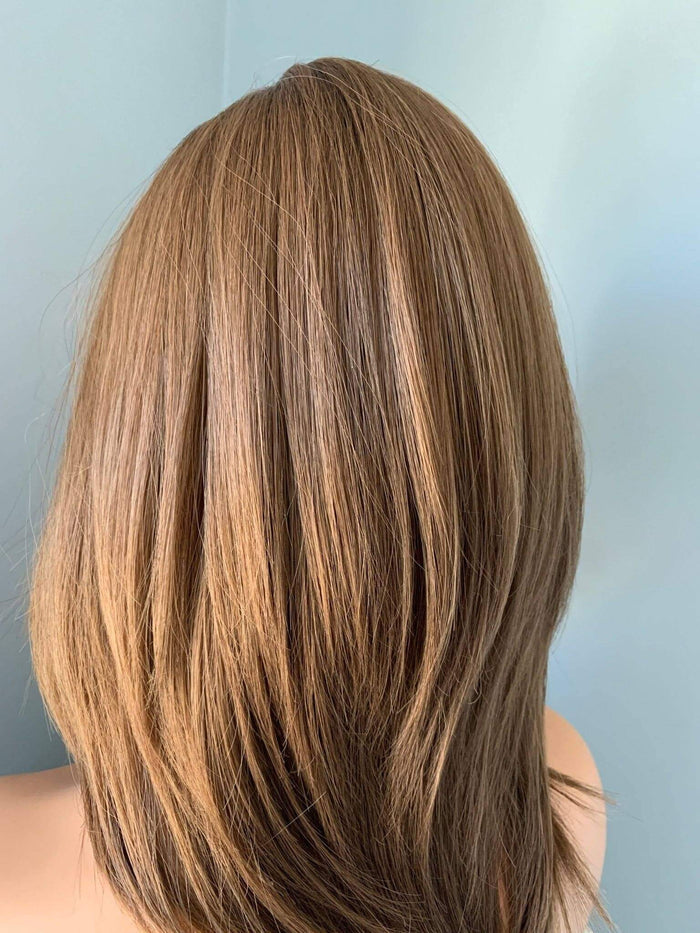 Back view of a person with long, straight, brown hair against a light blue background