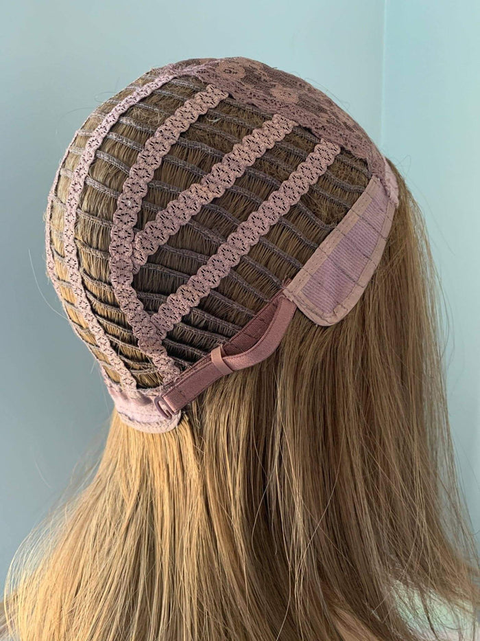 Brown wig with pink lace front on a mannequin head against a light blue background