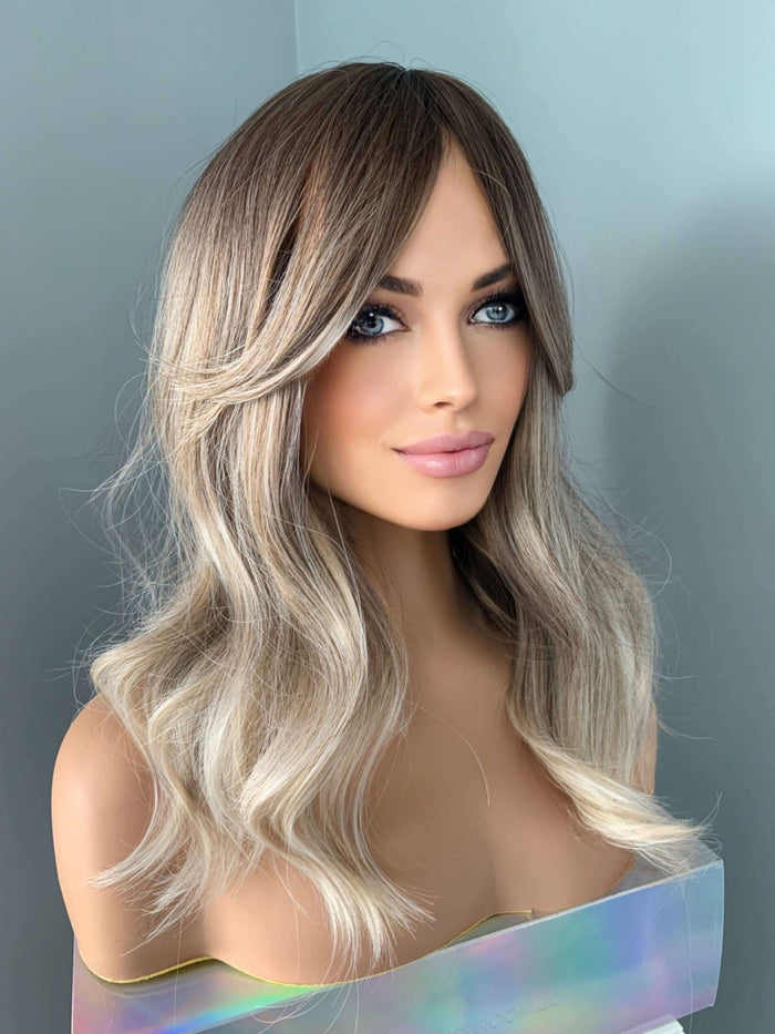 Harlow Rooted Ash Light Brown Wig with Bangs displayed on a mannequin with loose, beachy waves.
