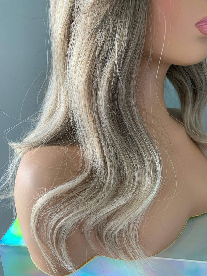 Harlow Rooted Ash Light Brown Wig with Bangs featuring loose waves and feathered bangs.