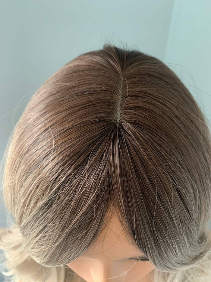 Top view of the Harlow Rooted Ash Light Brown Wig with Bangs, showcasing its soft texture and natural color blend.