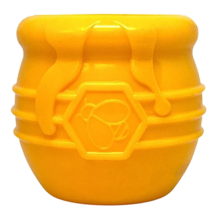 The SODA PUP HONEY POT DOG TREAT DISPENSER - YELLOW LARGE is a durable, barrel-shaped plastic enrichment toy for dogs, featuring a hexagonal pattern and a bee symbol on the side that mimics a honey pot. Shown against a plain white background, this puzzle feeder doubles as a treat dispenser to provide mental stimulation for your pup.