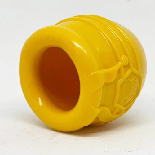 The HONEY POT DOG TREAT DISPENSER - YELLOW LARGE by SODA PUP is a durable yellow plastic container designed in the shape of a honey pot, featuring raised honey drips and a hexagon with a bee symbol on the front. This enrichment toy provides mental stimulation for dogs, making it an ideal treat dispenser for playtime.