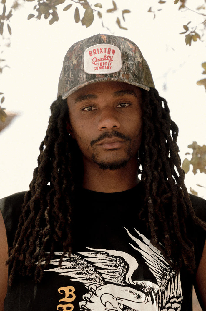 Unisex Hubal Netplus Trucker Hat in the color Tree Camo/Olive - Men's Lifestyle image