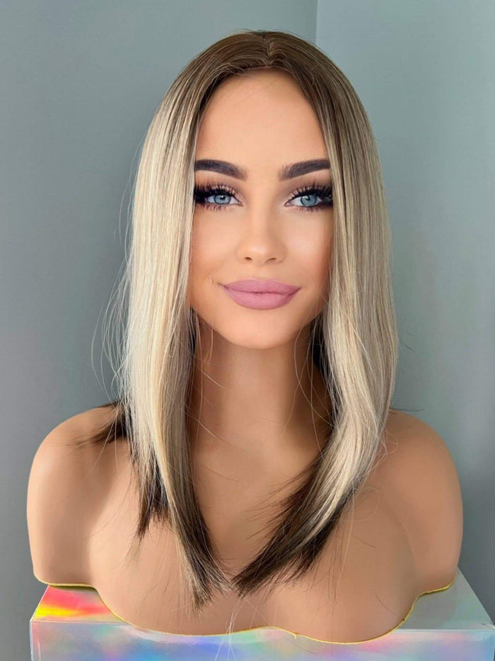 Jenna Short Rooted Blonde Wig with Low Lites showcasing sleek mid-length hair and face-framing layers.