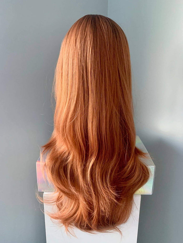 Auburn wig with bangs featuring long, flowing waves displayed on a mannequin.