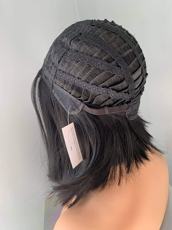 Black lace front wig on a mannequin head with a visible tag against a light gray background