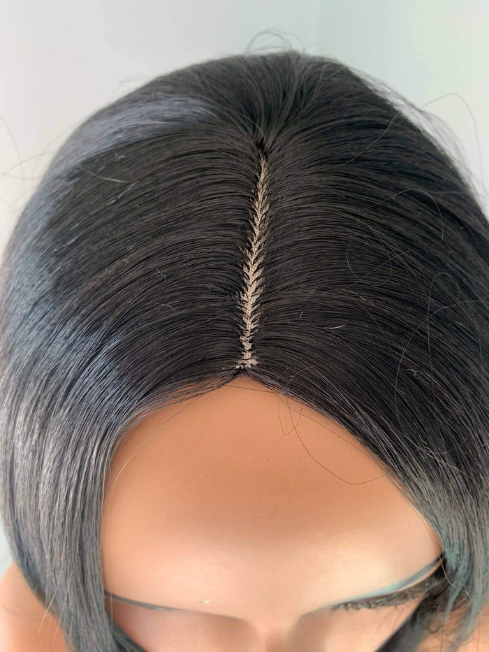 Mannequin head with a gray wig on a white background