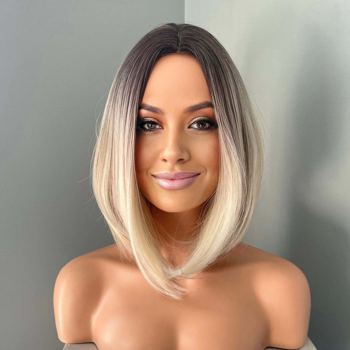 Model showcasing the Katya Short Blonde Rooted Synthetic Bob Wig by The Extension Room, featuring a sleek, stylish look.
