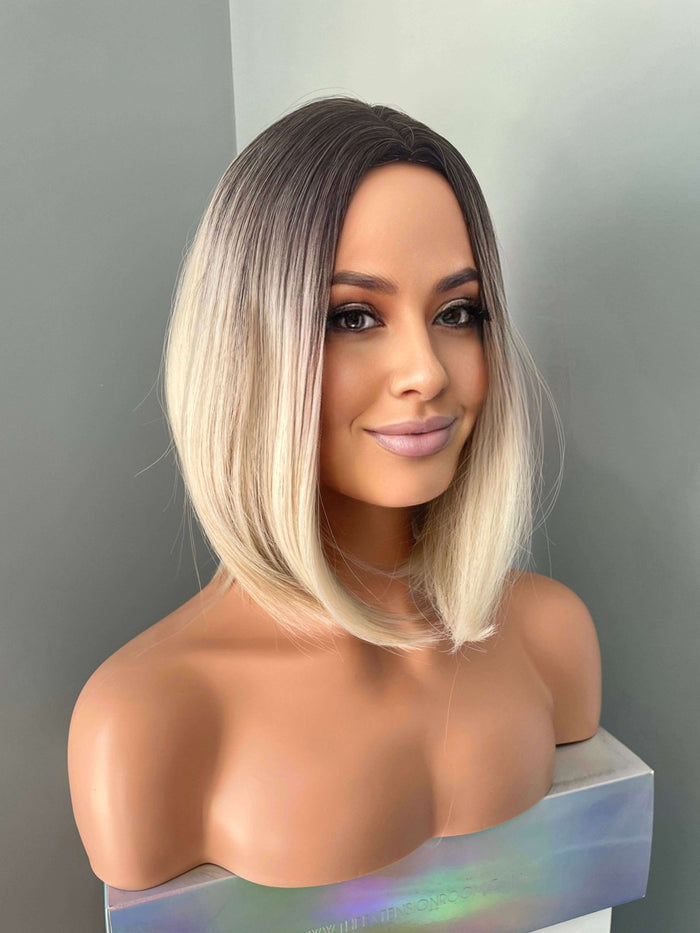 Short Blonde Rooted Synthetic Bob Wig displayed on a mannequin head, featuring a sleek silhouette and modern middle part.