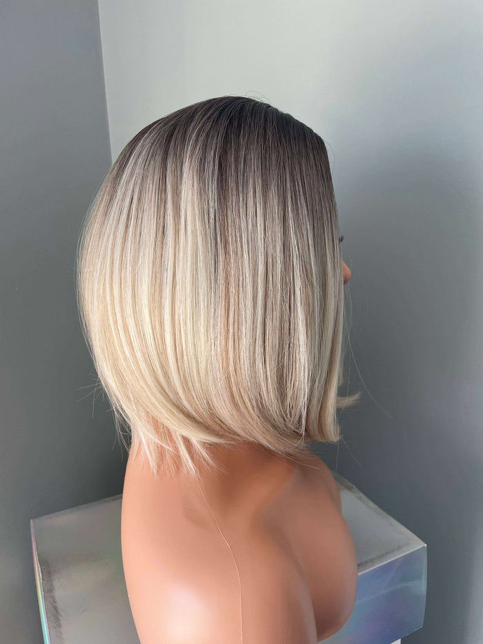 Side view of Katya Short Blonde Rooted Synthetic Bob Wig showcasing sleek ombre blend and modern shoulder-length style.