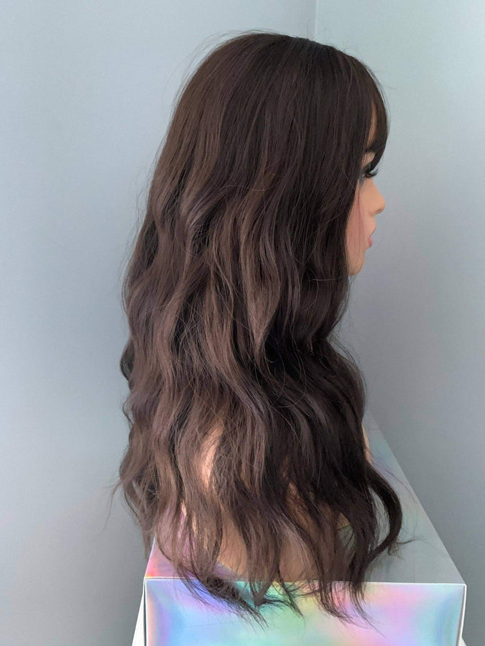 Profile view of the Kayla Long Dark Brown Wig with Bangs featuring loose wavy strands, perfect for everyday style.