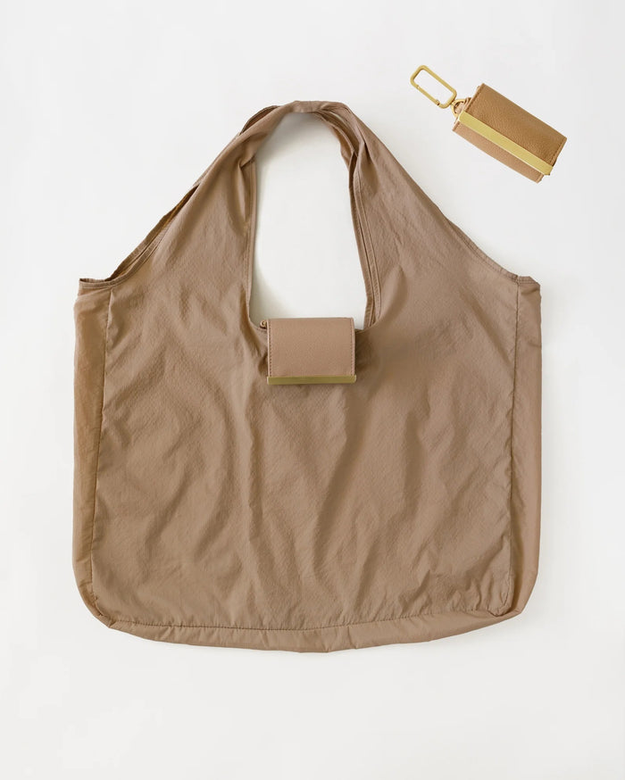 KEOTE - KEYCHAIN TOTE IN CARAMEL by KEOTE, a compact caramel tote with an attached small rectangular pouch on the handle, shown on a white background. A matching keychain tote pouch is placed above the stylish reusable bag.