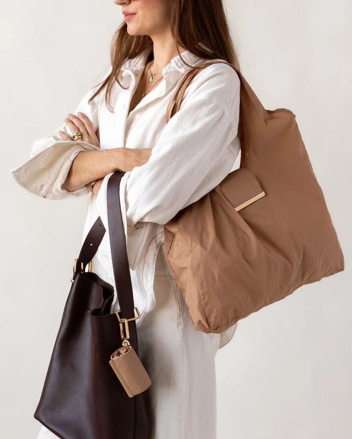 KEOTE - KEYCHAIN TOTE IN CARAMEL by KEOTE, a compact caramel tote with an attached small rectangular pouch on the handle, shown on a white background. A matching keychain tote pouch is placed above the stylish reusable bag.