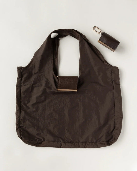 The KEOTE - KEYCHAIN TOTE IN ESPRESSO by KEOTE is a dark brown compact tote with two handles, featuring a detachable rectangular case in the center and an additional closed keychain tote, displayed on a light background.
