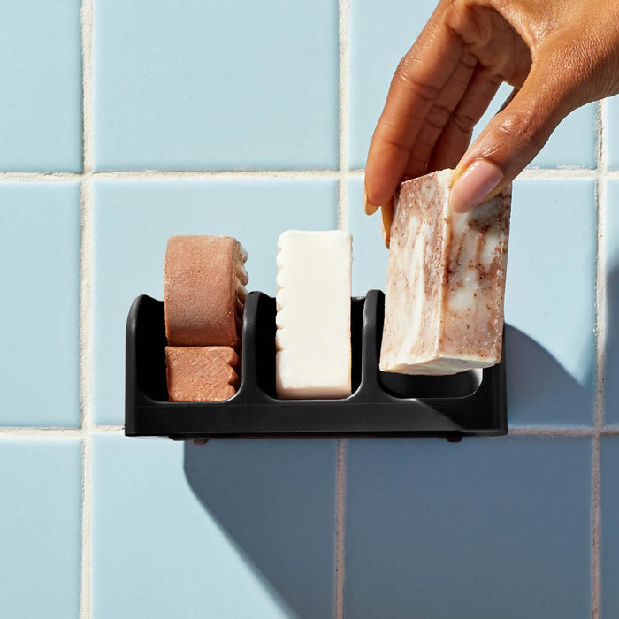 Eco-friendly KITSCH self-draining soap dish, crafted from recycled plastic with three compartments. Displayed in front of its packaging labeled "KITSCH - SELF DRAINING SOAP DISH".