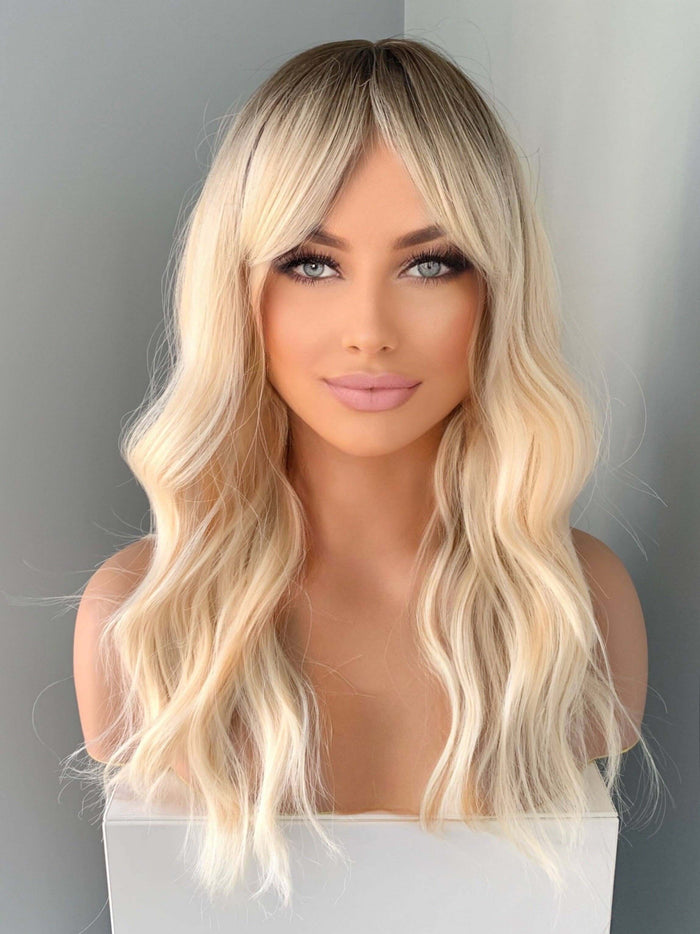 Krista Wavy Blonde Wig with Bangs showcasing soft waves and face-framing bangs for a natural look.