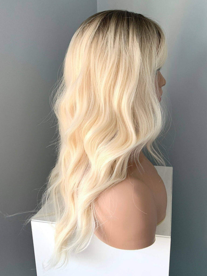 Krista Wavy Blonde Wig with Bangs showcasing soft waves and a natural look from the side view.