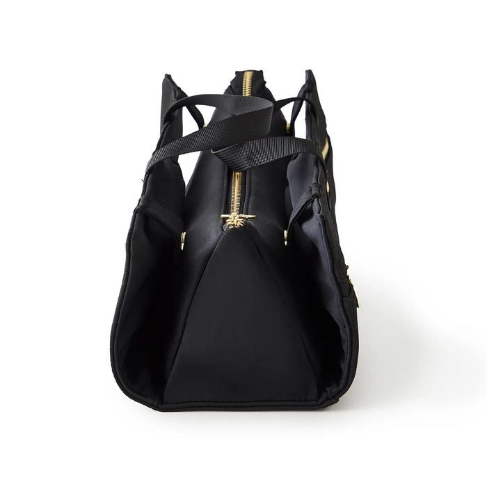 The KUSSHI - HAIR TOOLS TRAVEL BAG IN BLACK by KUSSHI is a rectangular neoprene organizer with two handles, gold zippers, and a white front label, shown against a white background.