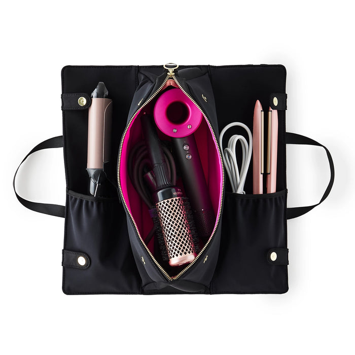 The KUSSHI - HAIR TOOLS TRAVEL BAG IN BLACK by KUSSHI is a rectangular neoprene organizer with two handles, gold zippers, and a white front label, shown against a white background.