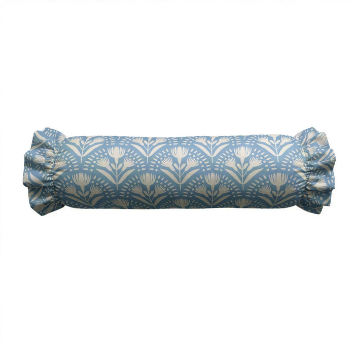 A close-up of the LOOM AND CLOTH - SERENA RUFFLED BOLSTER PILLOW by LOOM & CLOTH showcases a vintage-chic, blue cotton pillow featuring a delicate white floral pattern and ruffled edge, set against a white background.