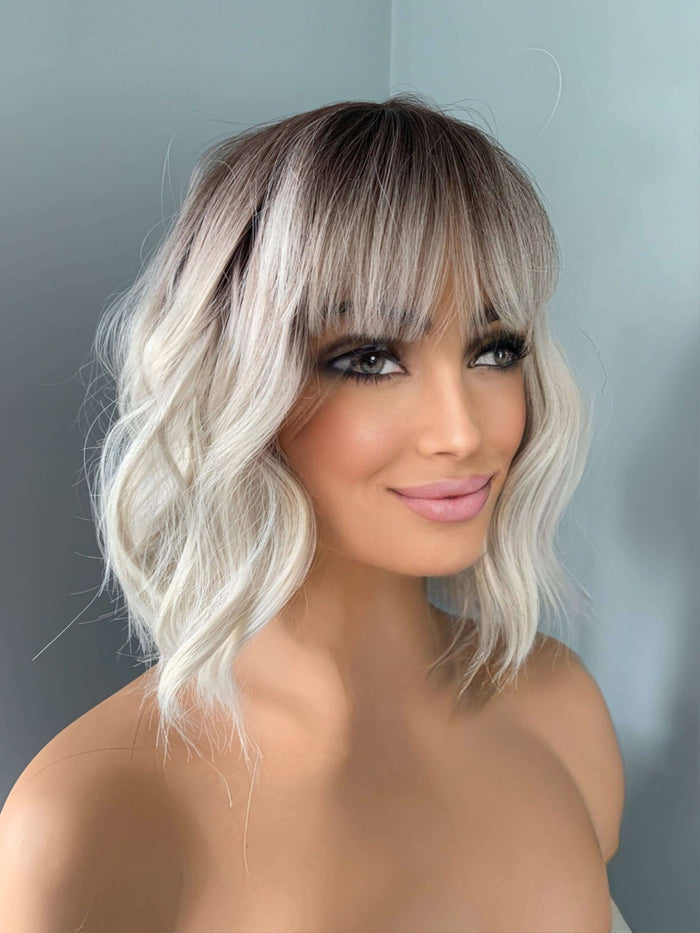 Lucy Short Bob Wig with Bangs styled on a mannequin, showcasing soft waves and full bangs for a trendy look.