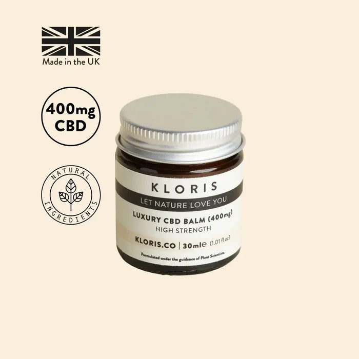 Kloris CBD balm jar with branding and product details on a beige background