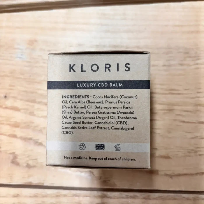 Kloris Luxury CBD Balm packaging with ingredient list on a wooden surface