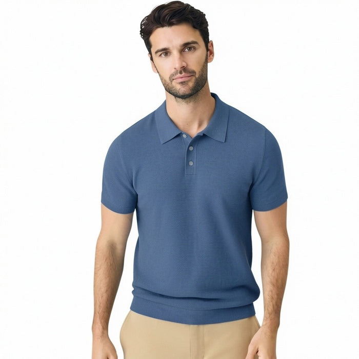 A man with short dark hair and a beard wears the MACK WELDON TECH LINEN SWEATER POLO in Deep Lagoon Heather, made with COOLMAX technology, and beige pants. He looks down, left arm bent, posed against a plain light gray background.