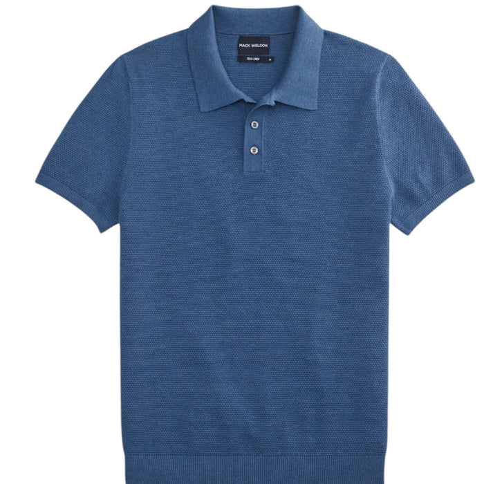 A man with short brown hair and a trimmed beard wears the MACK WELDON TECH LINEN SWEATER POLO in Deep Lagoon Heather and beige pants, standing against a plain white background.