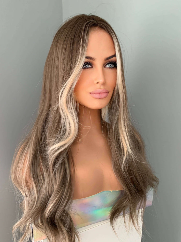Mannequin head with long, wavy, two-tone hair against a neutral background