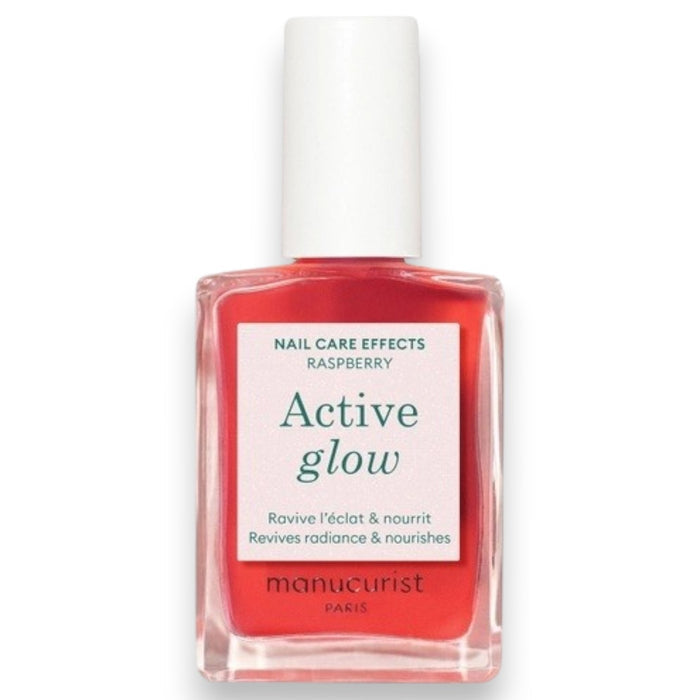 A clear bottle of MANUCURIST - ACTIVE™ GLOW CARE POLISH from MANUCURIST INC features a white cap and vibrant pink liquid. The label displays “Active Glow” and showcases its nail care benefits, grape scent, and nourishing qualities. This bio-sourced polish strengthens nails while providing a sophisticated glass-nails effect for a radiant, healthy-looking finish.