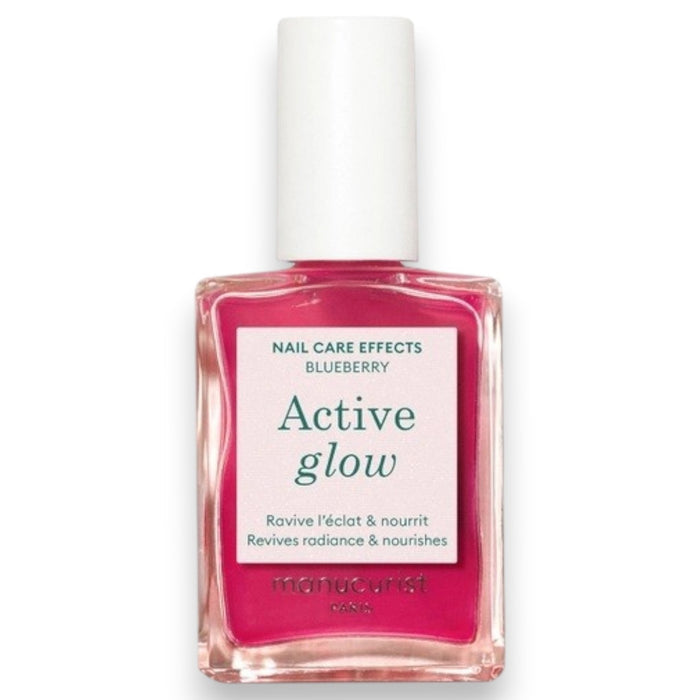 A clear bottle of MANUCURIST - ACTIVE™ GLOW CARE POLISH from MANUCURIST INC features a white cap and vibrant pink liquid. The label displays “Active Glow” and showcases its nail care benefits, grape scent, and nourishing qualities. This bio-sourced polish strengthens nails while providing a sophisticated glass-nails effect for a radiant, healthy-looking finish.
