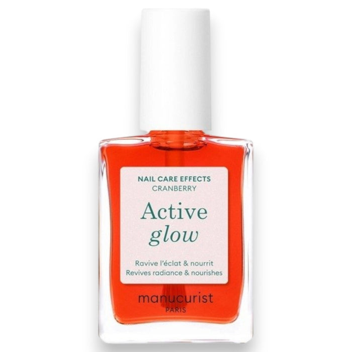 A clear bottle of MANUCURIST - ACTIVE™ GLOW CARE POLISH from MANUCURIST INC features a white cap and vibrant pink liquid. The label displays “Active Glow” and showcases its nail care benefits, grape scent, and nourishing qualities. This bio-sourced polish strengthens nails while providing a sophisticated glass-nails effect for a radiant, healthy-looking finish.