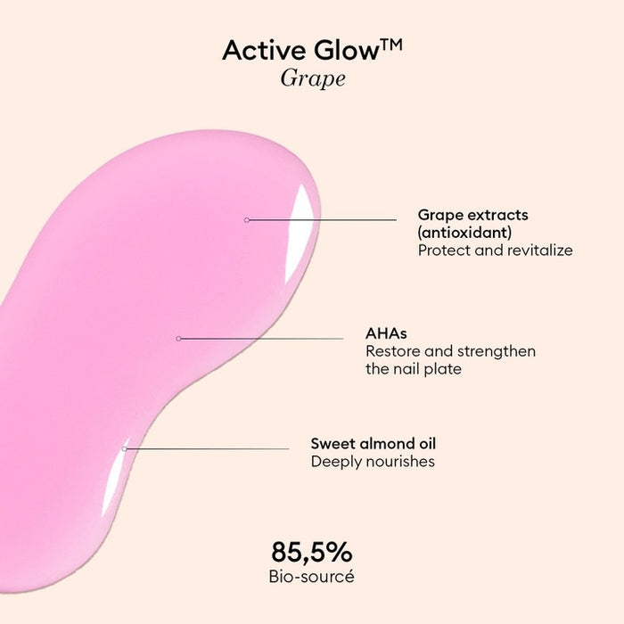 A clear bottle of MANUCURIST - ACTIVE™ GLOW CARE POLISH from MANUCURIST INC features a white cap and vibrant pink liquid. The label displays “Active Glow” and showcases its nail care benefits, grape scent, and nourishing qualities. This bio-sourced polish strengthens nails while providing a sophisticated glass-nails effect for a radiant, healthy-looking finish.
