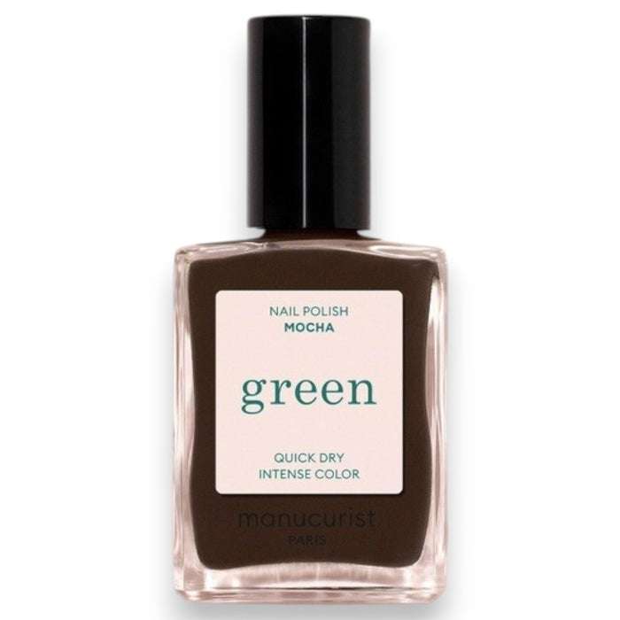A hand with short nails painted in MANUCURIST - GREEN™ Nail Polish in Mocha by MANUCURIST INC rests on a shiny, metallic, wavy-edged object against a deep red background.