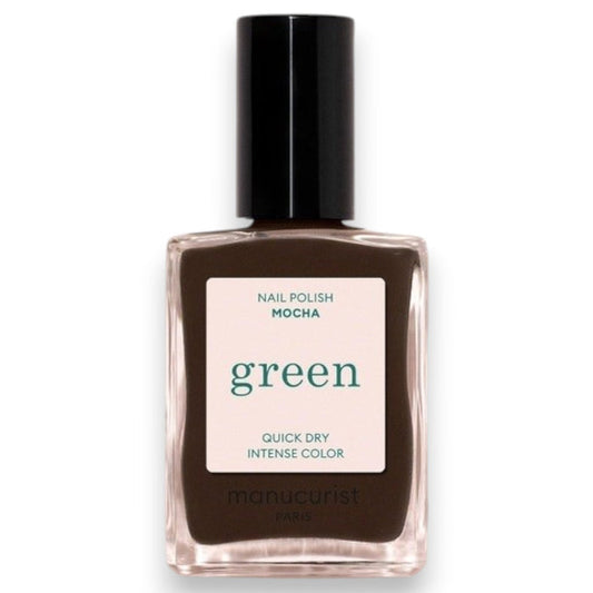 A hand with short nails painted in MANUCURIST - GREEN™ Nail Polish in Mocha by MANUCURIST INC rests on a shiny, metallic, wavy-edged object against a deep red background.