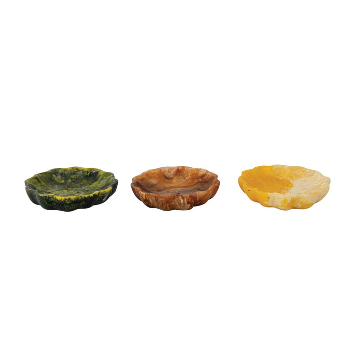 Three CREATIVE COOP MARBLED RESIN FLOWER-SHAPED SOAP DISHES in green, brown, and yellow are displayed side by side on a plain white background. Each decorative dish features scalloped edges and a unique marbled pattern.