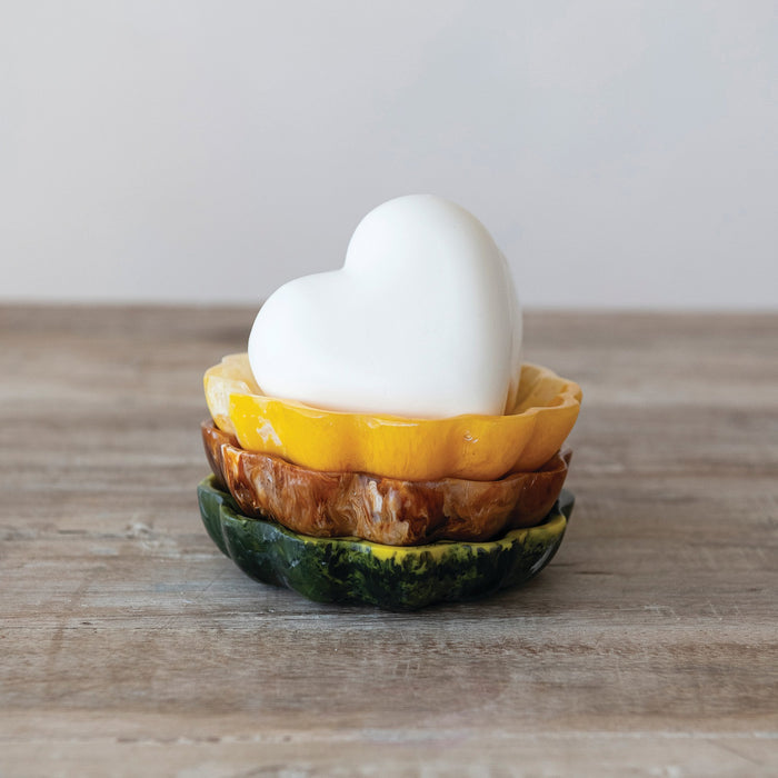 Three CREATIVE COOP MARBLED RESIN FLOWER-SHAPED SOAP DISHES in green, brown, and yellow are displayed side by side on a plain white background. Each decorative dish features scalloped edges and a unique marbled pattern.