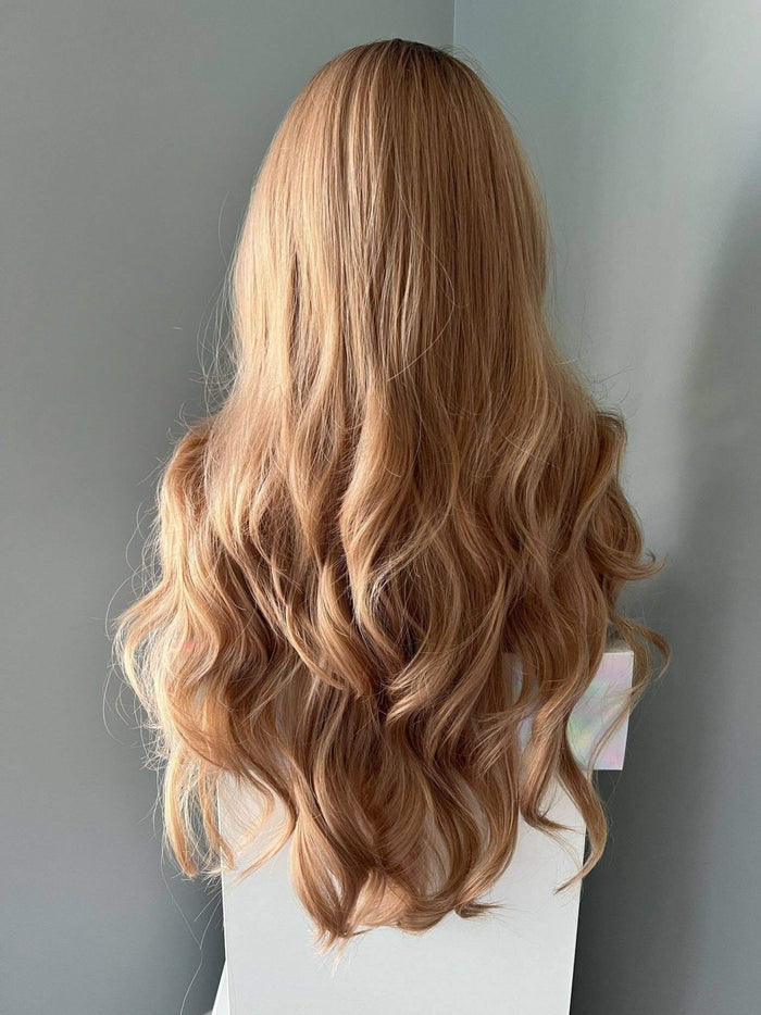 Long honey blonde curled wig with soft waves, showcasing natural beauty and effortless style.