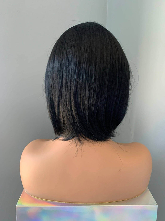 Mannequin head with black hair styled in a bob cut against a plain background
