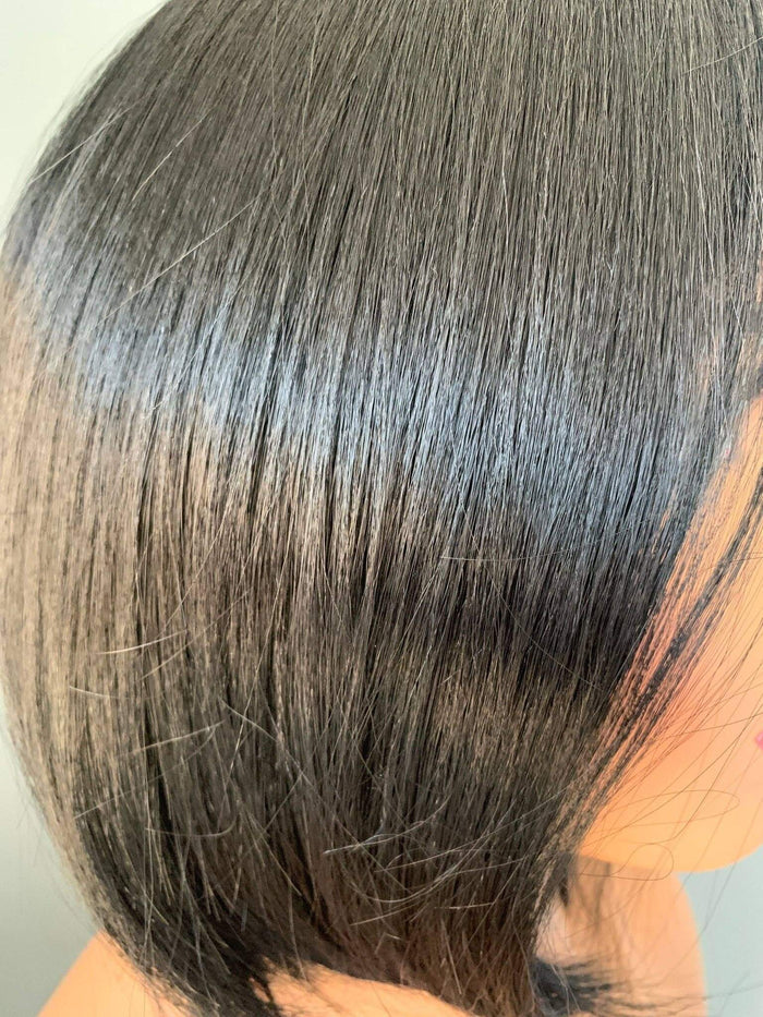 Close-up of a person with gray hair on a neutral background