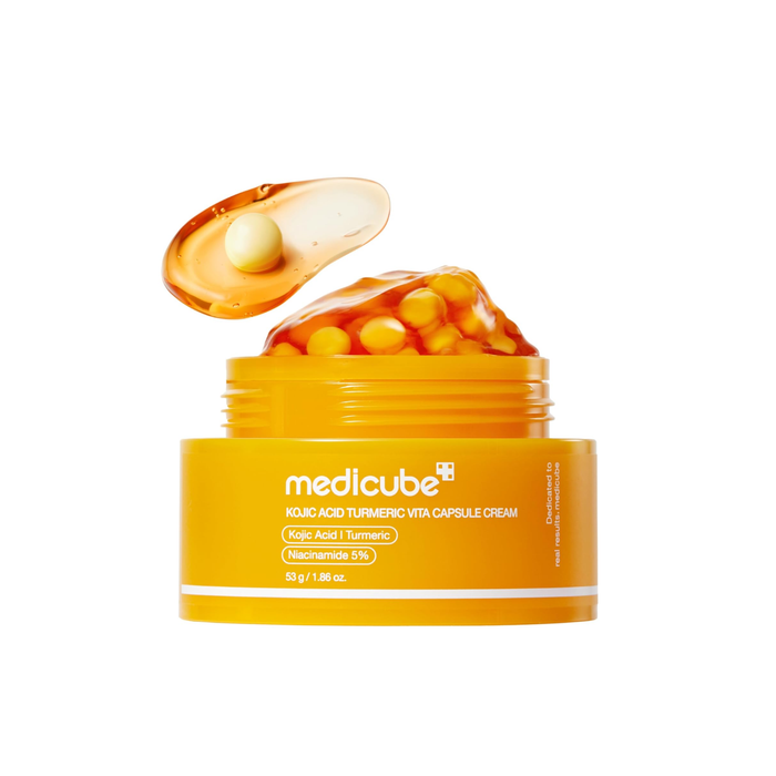 MEDICUBE Kojic Acid Turmeric Vita Capsule Cream is a brightening and revitalizing moisturizer designed to improve uneven skin tone and restore a healthy glow. Formulated with Kojic Acid, Turmeric Root Extract, and Niacinamide, it helps target dark spots while supporting a more balanced complexion. The capsule cream texture delivers active ingredients evenly into the skin, while Ceramides, Hyaluronic Acid, and Peptides help maintain hydration and strengthen the skin barrier. With added antioxidan