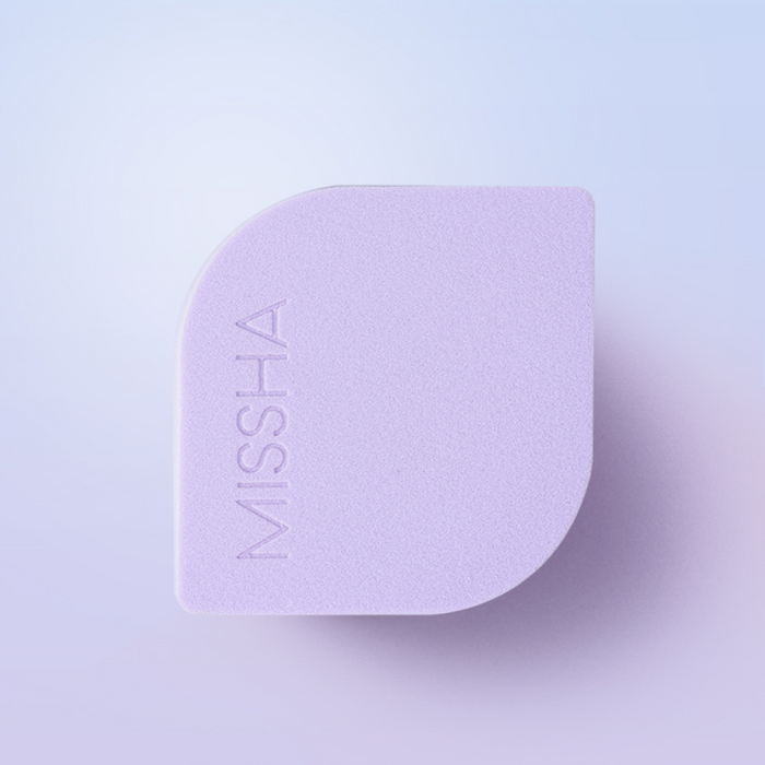 Top and front view of the MISSHA Layering Fit Puff, showing its unique shape with a pointed tip for precision and a flat surface for blending. The MISSHA logo is visible on the product.