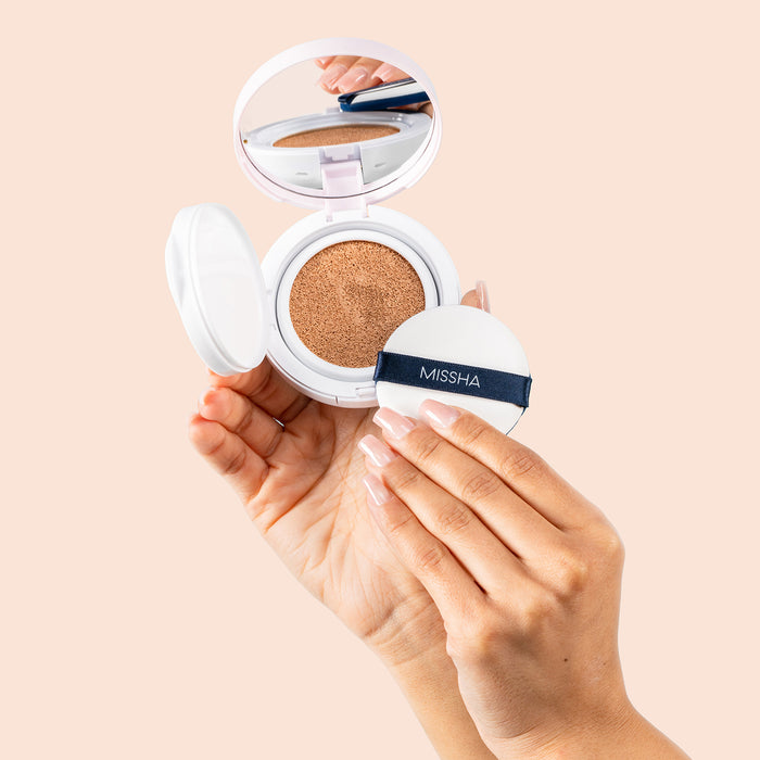Stylized shot of model hand holding compact and cushion applicator 25