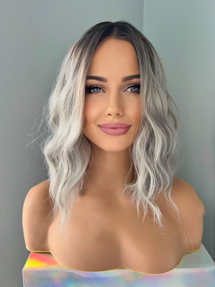 Woman with wavy, shoulder-length hair against a plain background