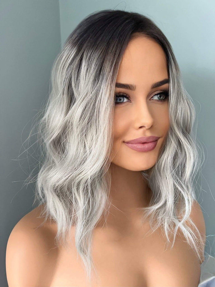 Woman with wavy, ombre hair in front of a neutral background